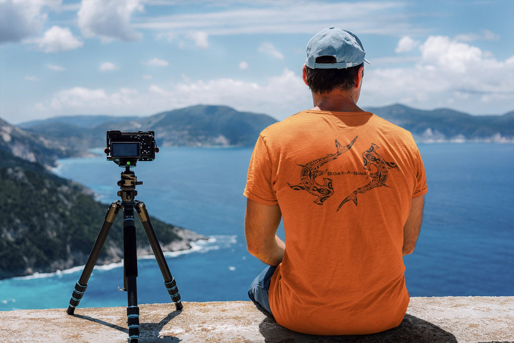 Man by the water wearing the Boat-A-Bing hammerhead sharks back-print boating shirt