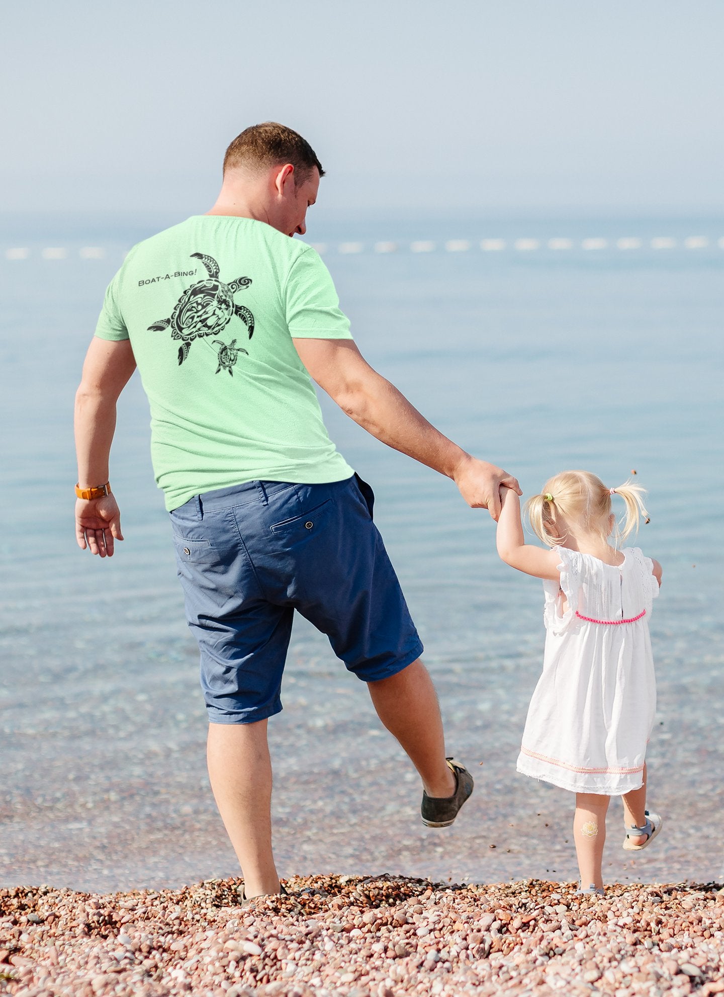 Dad and daughter at the shoreline in Boat-A-Bing Mama Turtle back-print boating shirts